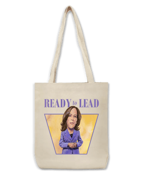 A beige tote bag shows the illustration of Kamala Harris with a serious face, purple dress and clasped hands. Ready to Lead is written above her.